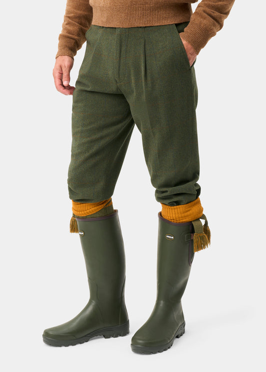 Combrook tweed shooting breeks in Mariner, mustard socks, green boots, and a brown sweater complete the outfit.