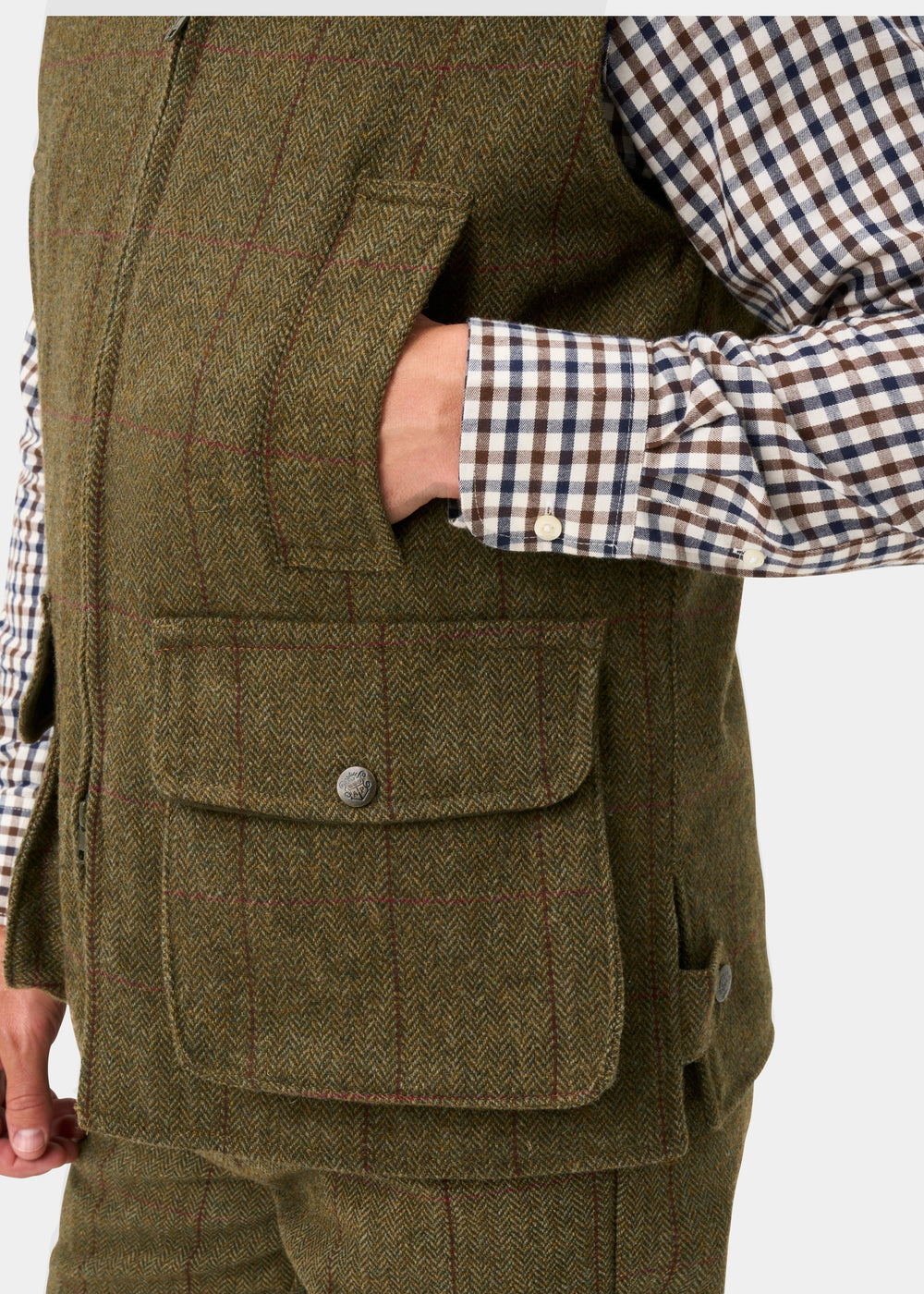 Rutland Men’s Tweed Water Repellent Waistcoat In Oakley with a hand in the chest pocket and a large buttoned pocket below.