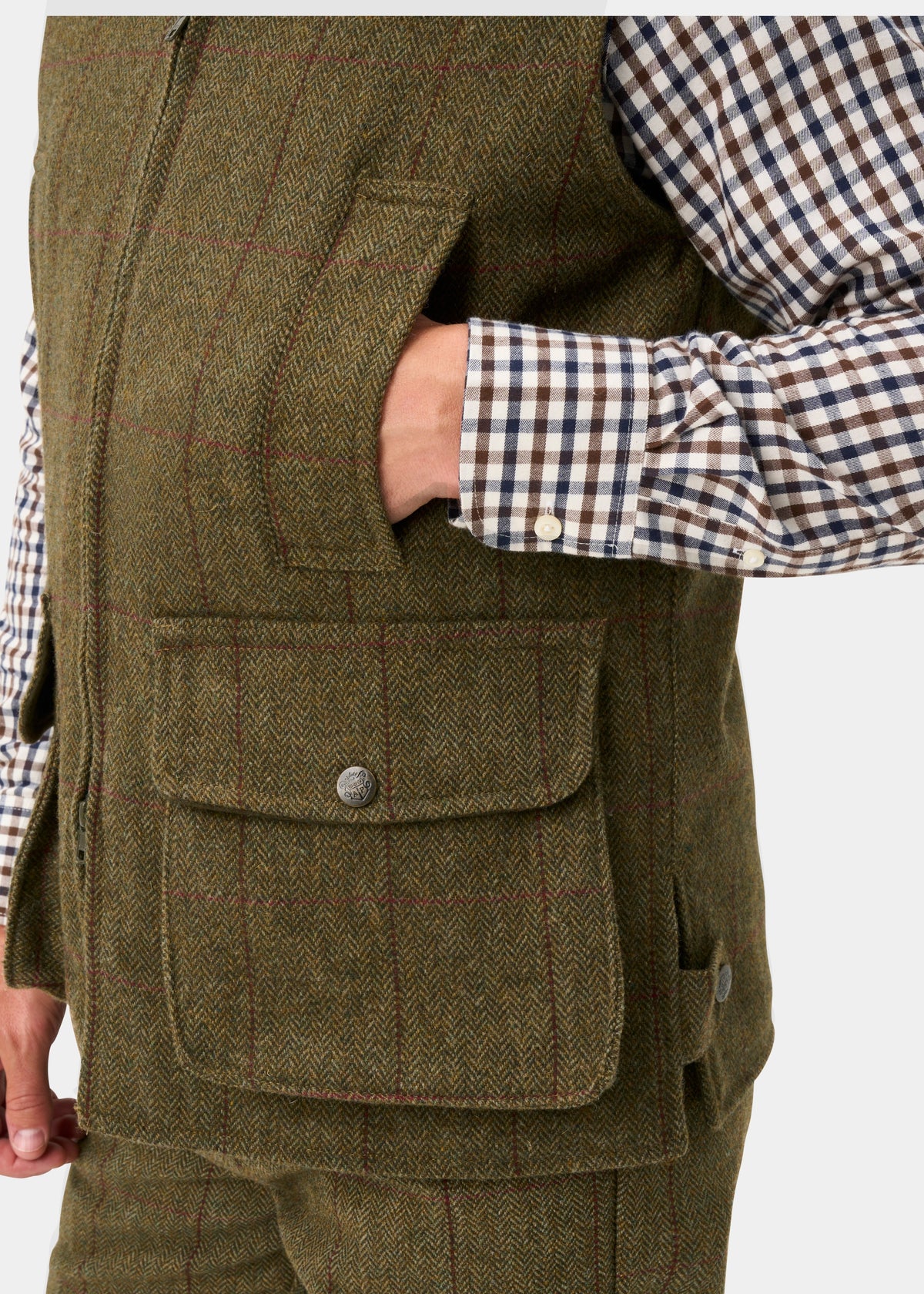Rutland Men’s Tweed Water Repellent Waistcoat In Oakley with a hand in the chest pocket and a large buttoned pocket below.