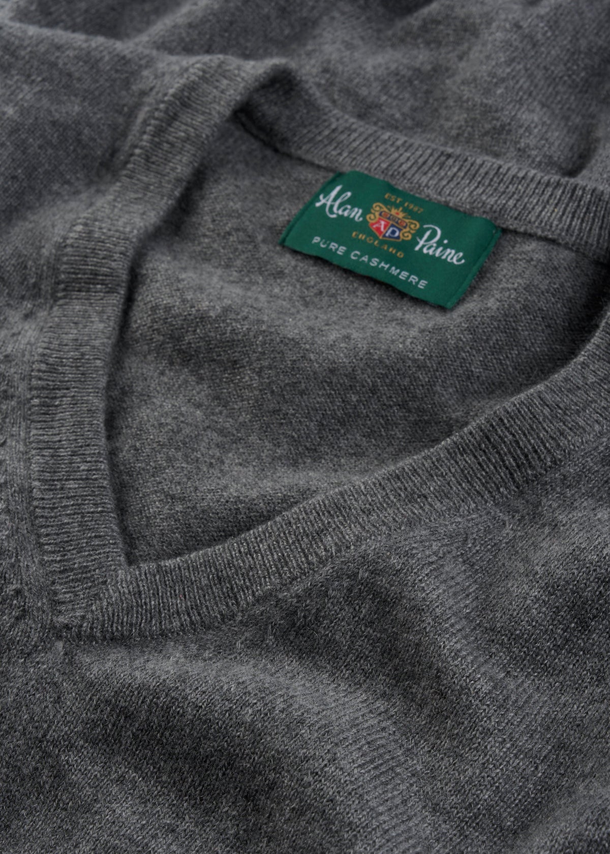 Close-up of the Haddington Pure Cashmere V-Neck Jumper in Derby with a green collar label, regular fit.