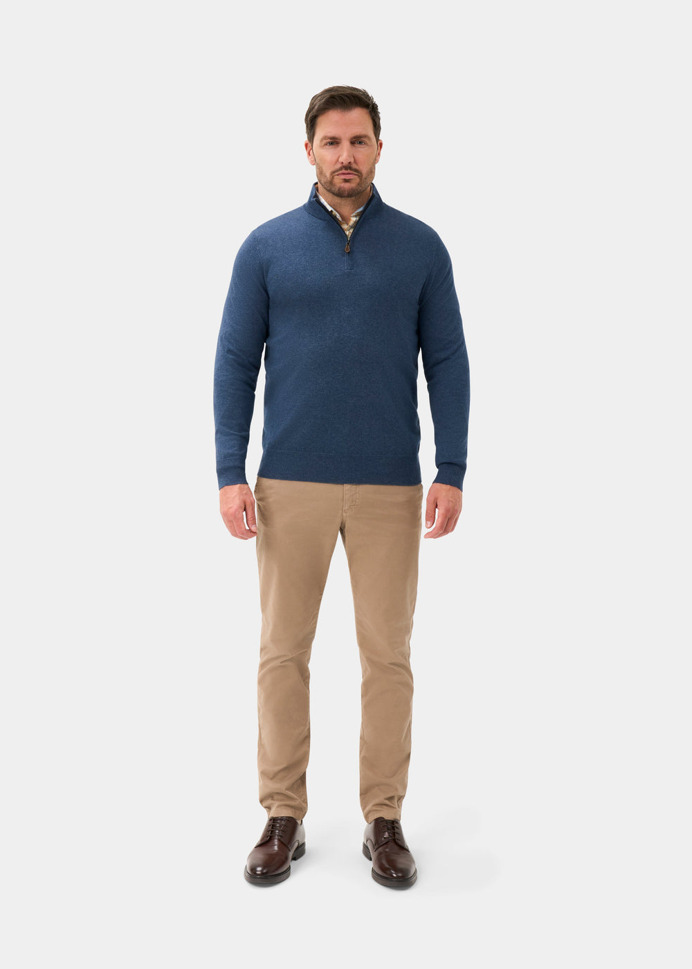Man in Ashfield Cotton Merino Quarter Zip Jumper in Denim, khaki pants, brown shoes, on a white background.