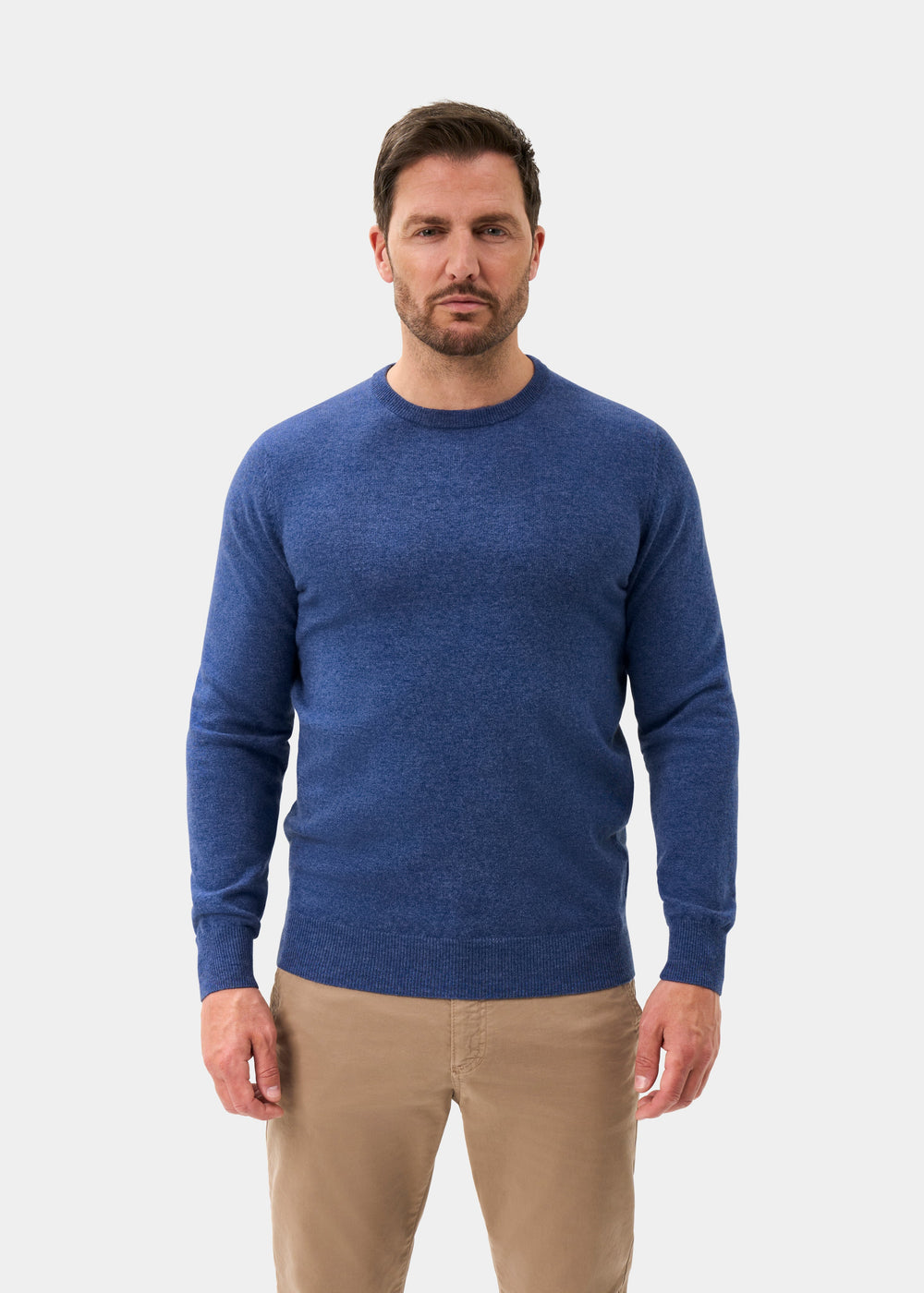 Man wears Brisbane Geelong Wool Crew Neck Jumper in Ullswater, regular fit, with khaki pants against a white background.