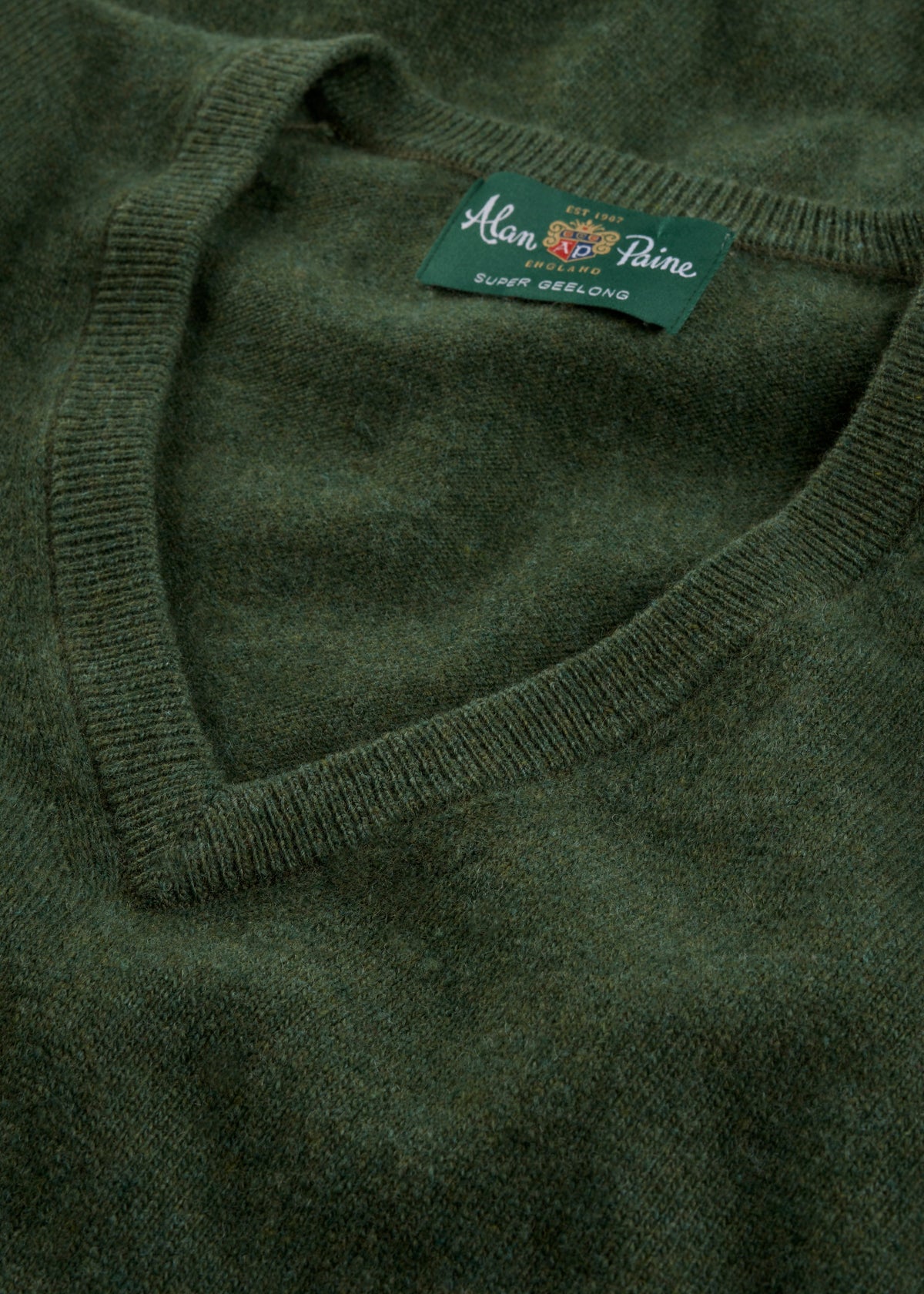 Close-up of the Albury Geelong Wool V-Neck Jumper in Rosemary, regular fit, with inner label visible.
