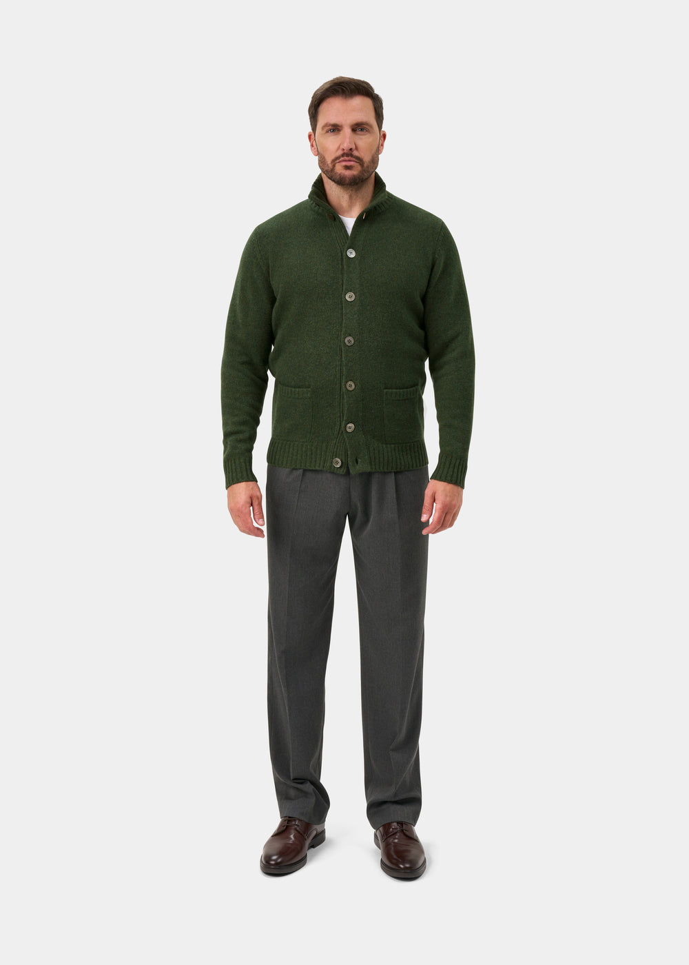 Man in Landford Lambswool Mock Neck Jumper in rosemary, gray pants, brown shoes, on plain white background.
