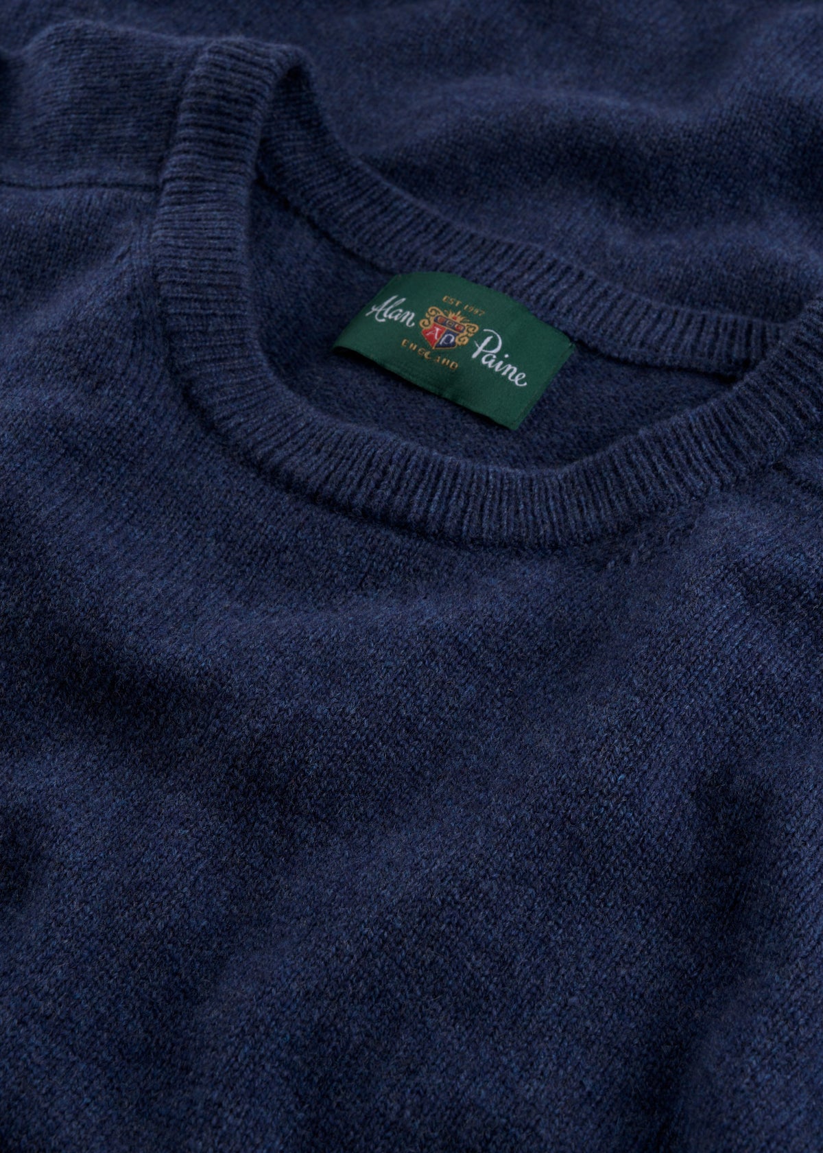 Close-up of the Dorset Lambswool Crew Neck Jumper in Rhapsody, classic fit, with a green John Smedley label.