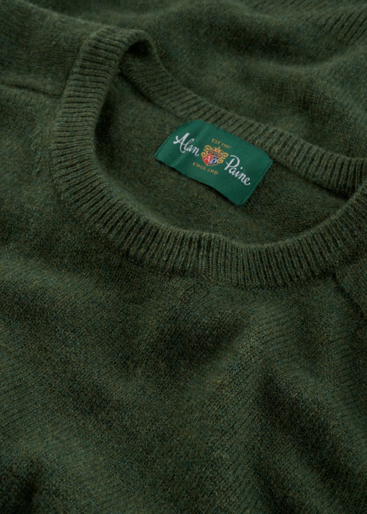 Close-up of Dorset Lambswool Crew Neck Jumper in Rosemary—Classic Fit, Alan Paine England label inside collar.