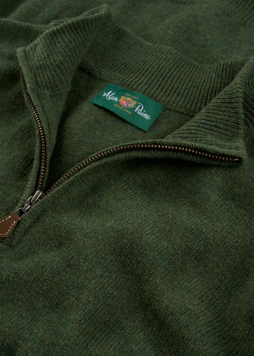 Sutherland Lambswool Quarter Zip Jumper In Rosemary: an olive green quarter-zip with a ribbed collar and neck label.