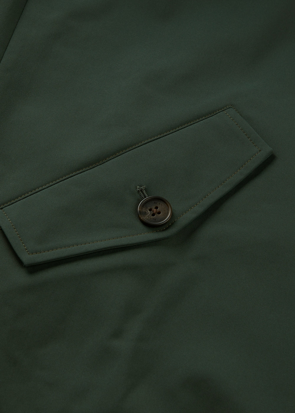 Close-up of a green pocket with flap and dark button on the Lakeward Men’s Reversible Bomber Jacket.