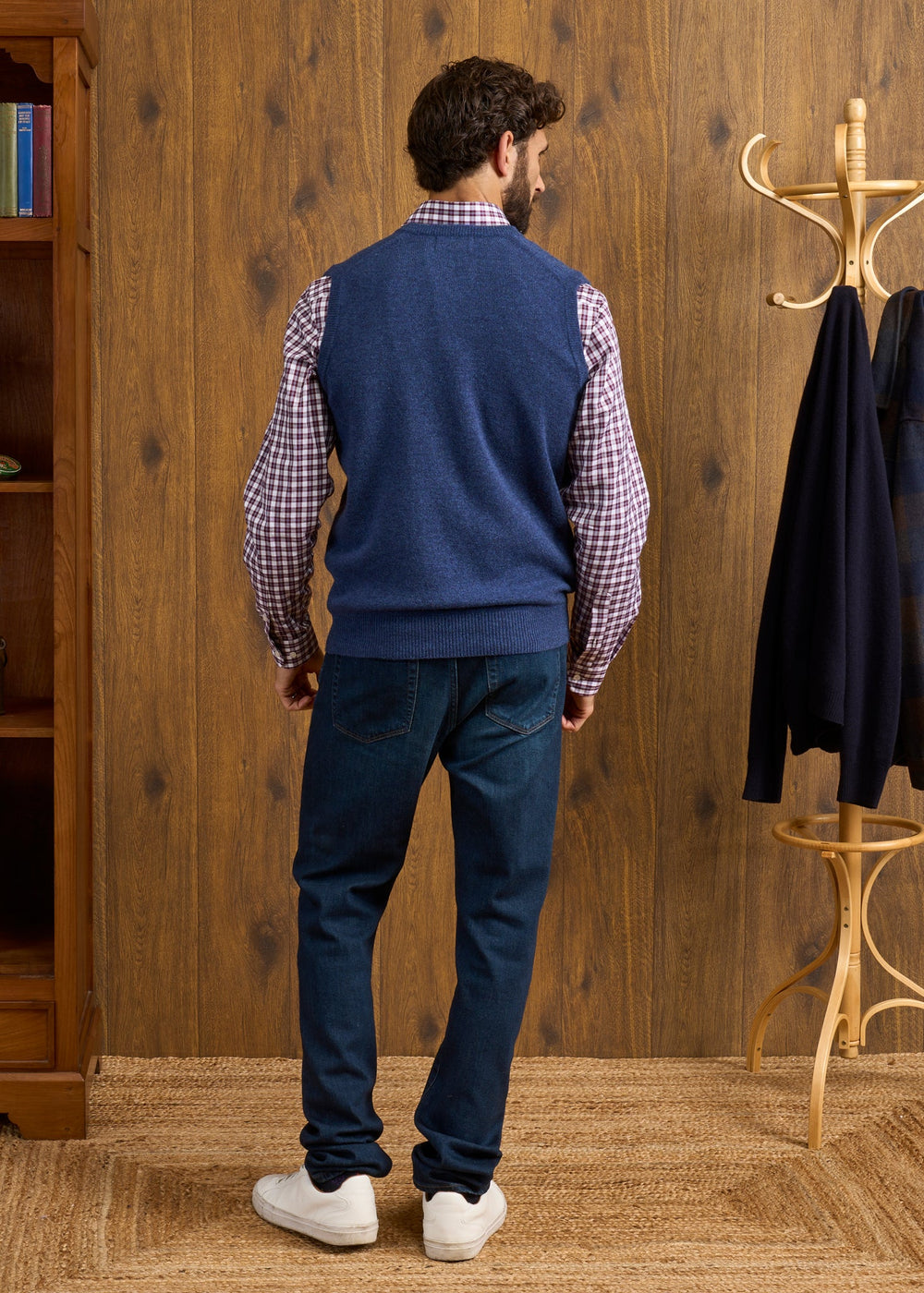 A man viewed from behind, wearing a Norfolk Lambswool V-Neck Slipover In Rhapsody over a plaid shirt and dark jeans.