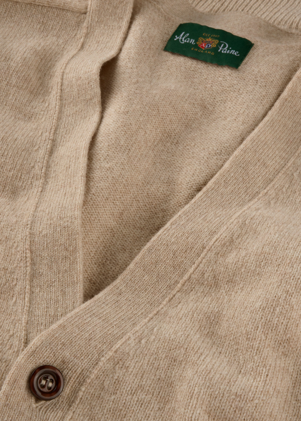Close-up of a beige cardigan with brand label