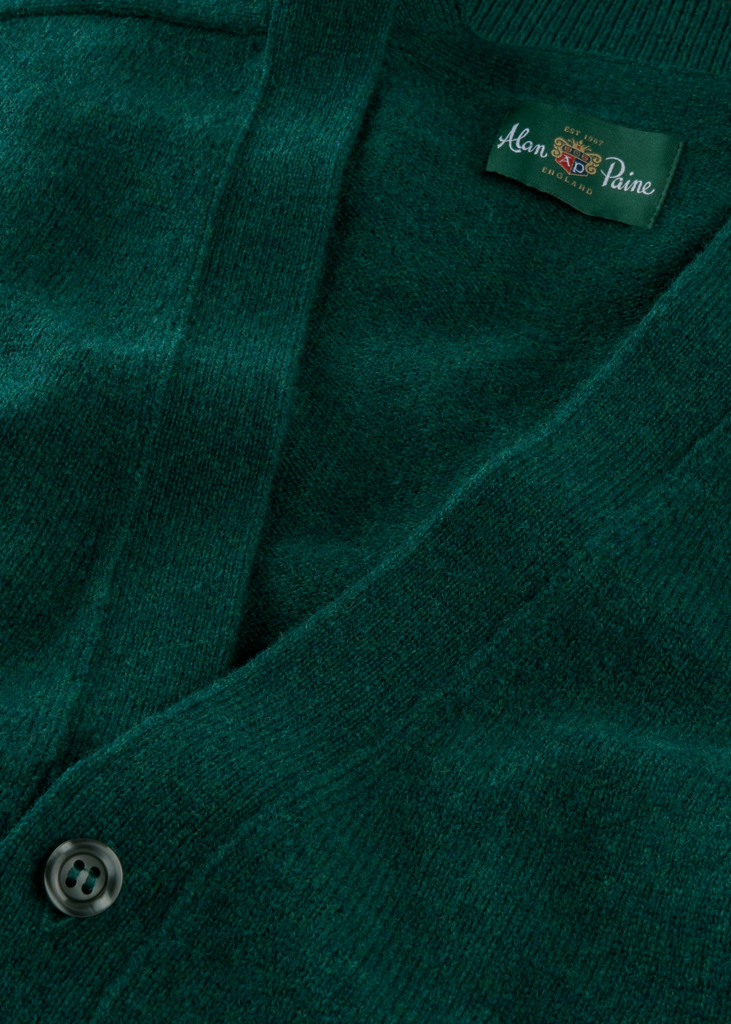 Close-up of a green cardigan with a brand label