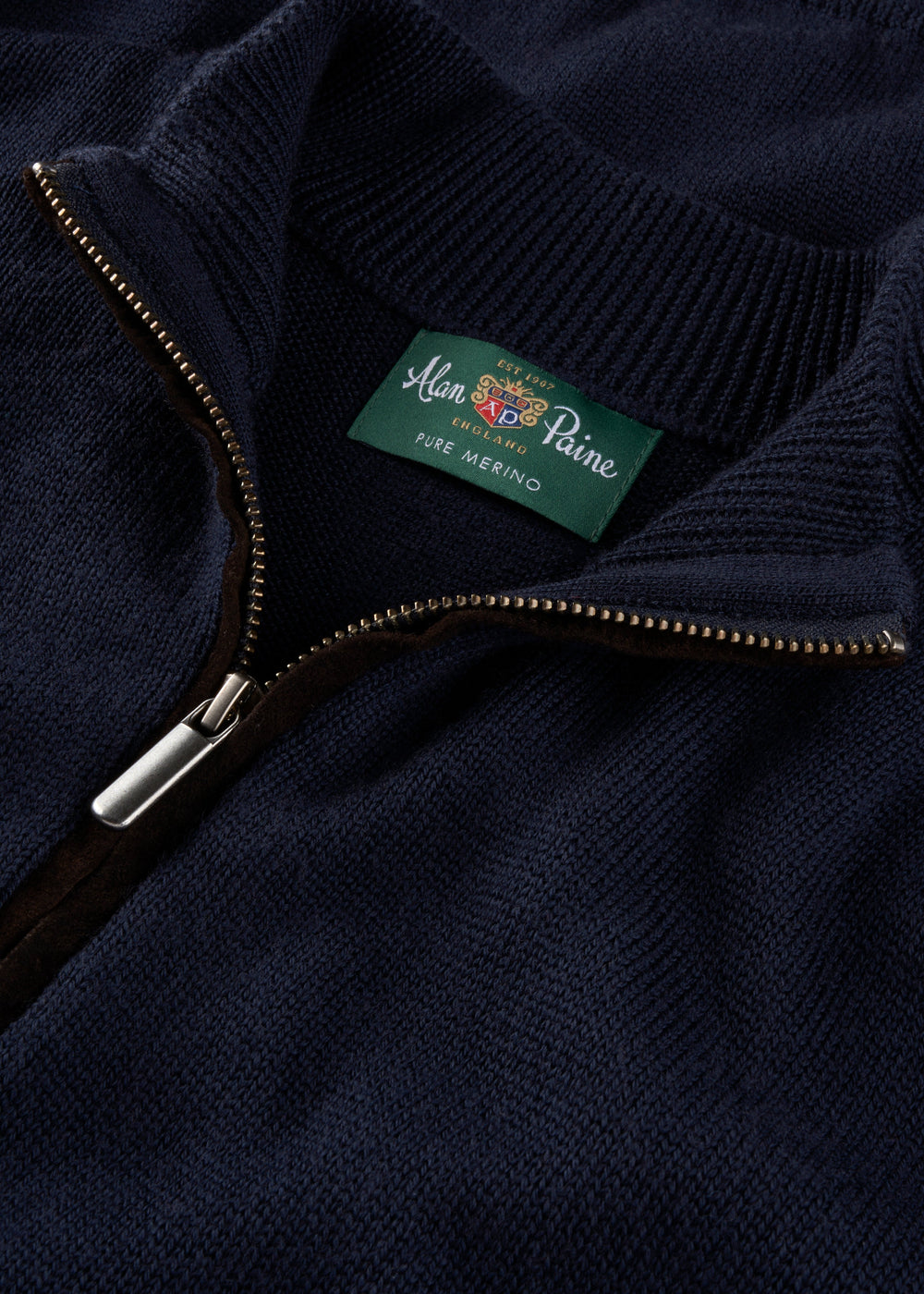 Close-up of the Kinmere Merino Wool Quarter Zip Jumper in Dark Navy, collar unzipped to reveal Alan Paine label.