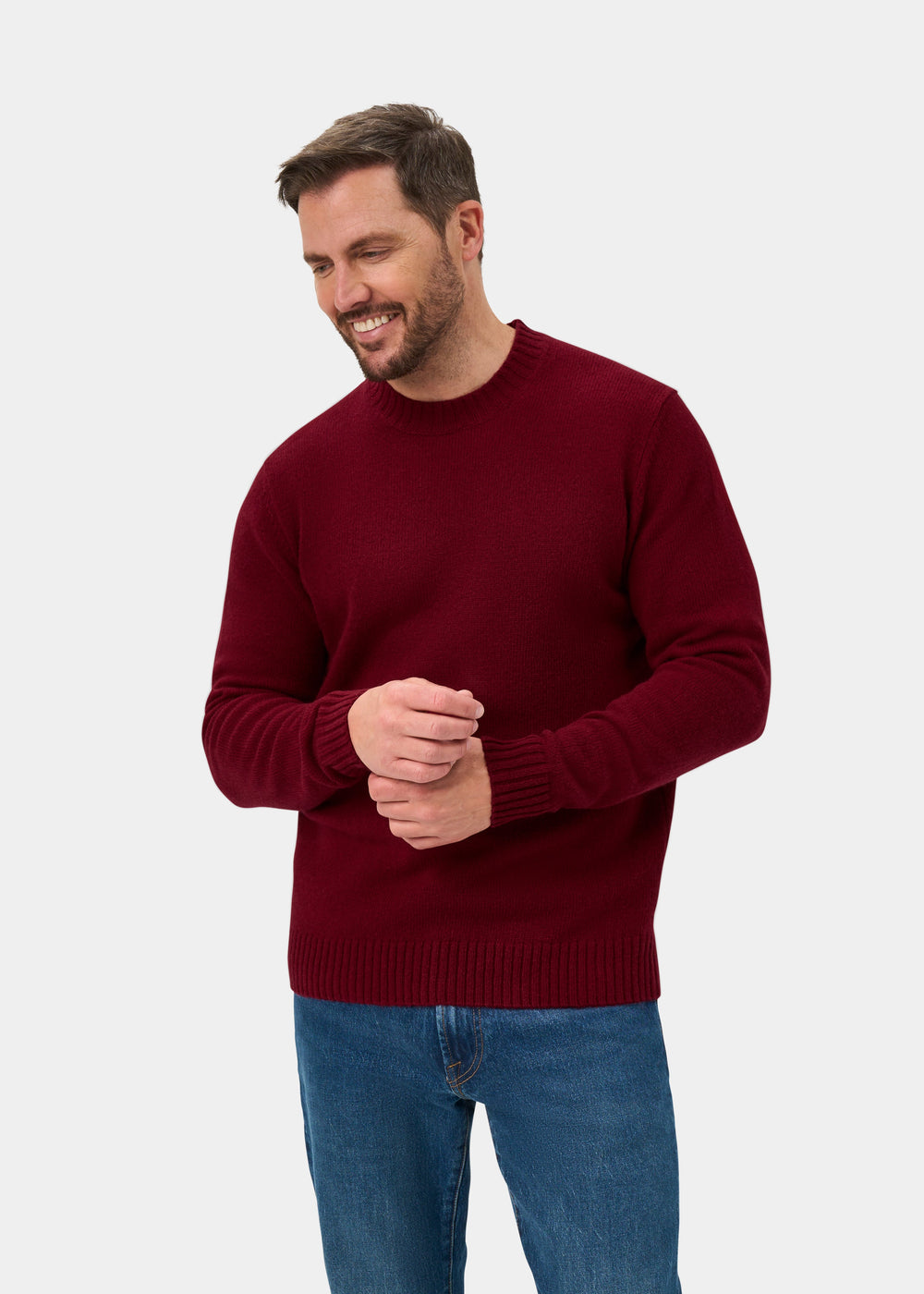 Man in a Kinnadie Supersoft Shetland Wool Crew Neck Jumper in Venetian, smiling and looking to the side.