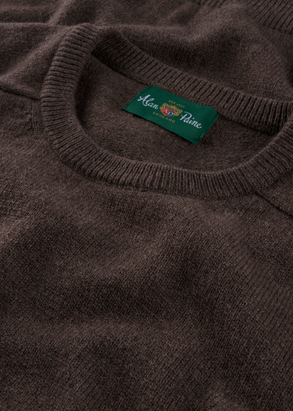 Close-up of a dark gray sweater with a brand label on the collar.