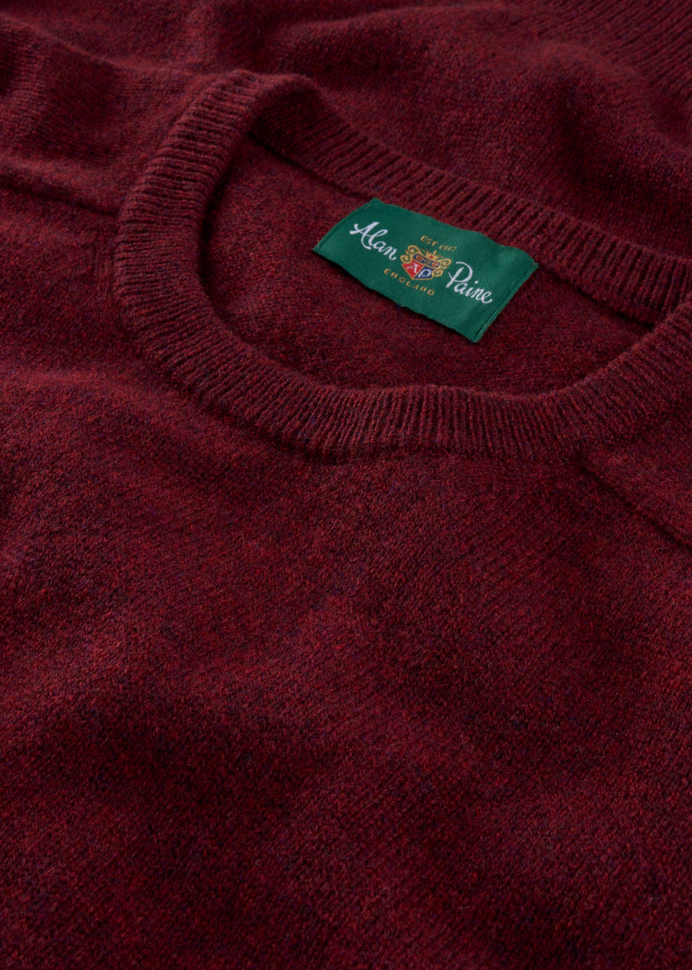 Close-up of a red jumper with a brand label on the collar.