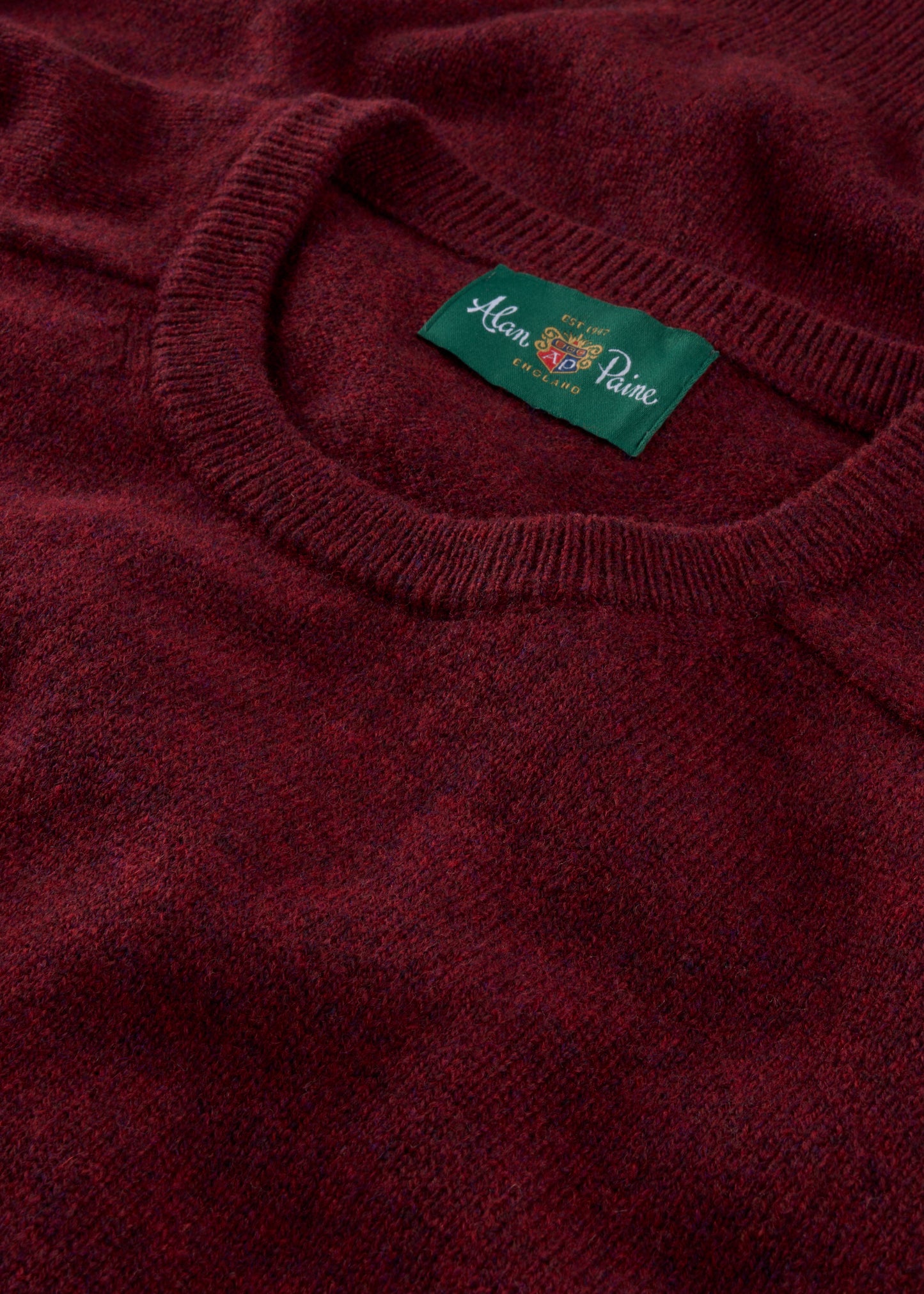 Close-up of a red jumper with a brand label on the collar.