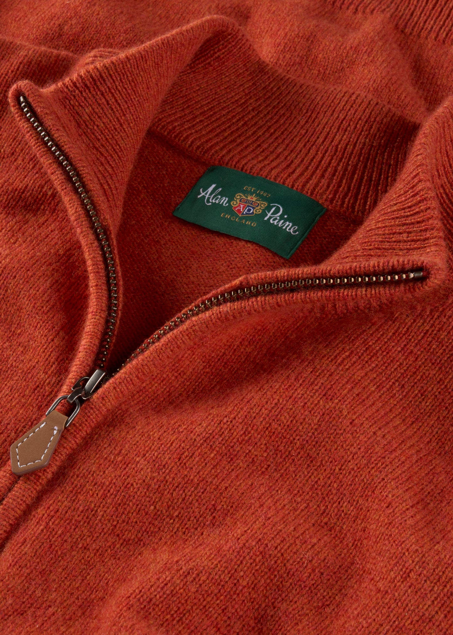Close-up of a orange sweater with a brand label